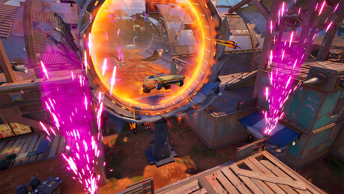 A yellow car jumping through a flaming hoop in Fortnite