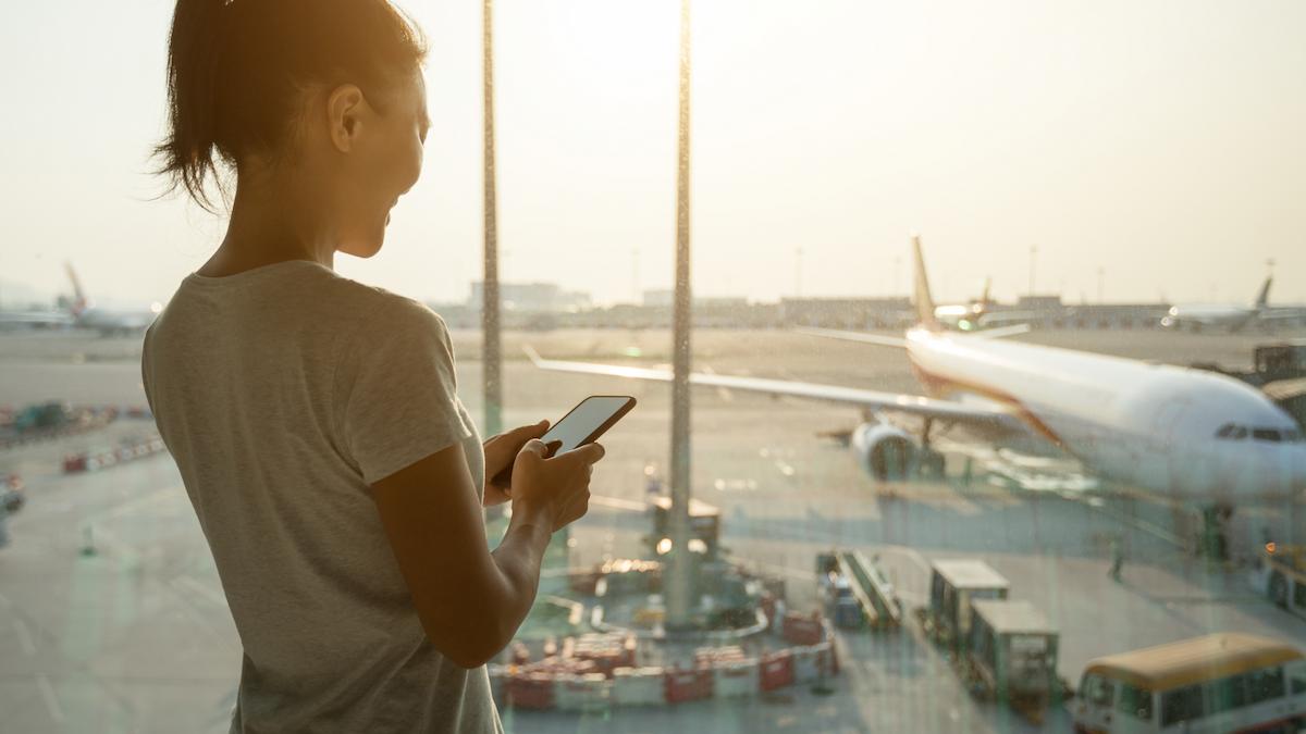 Woman at airport with phone in hand