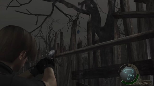 Resident Evil 4: Leon Kennedy points his gun at a blue medallion.