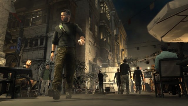 Splinter Cell Conviction: Sam Fisher casually walks through a town square at night, as suspicion men look on.