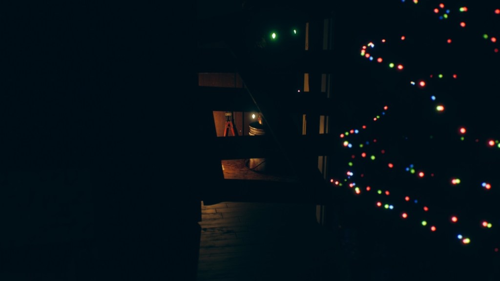 The player hides in September 7th, with Christmas lights illuminating the scene