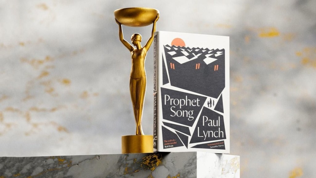 The novel "Prophet Song" by Paul Lynch stands next to the gold-colored Booker Prize award statue.