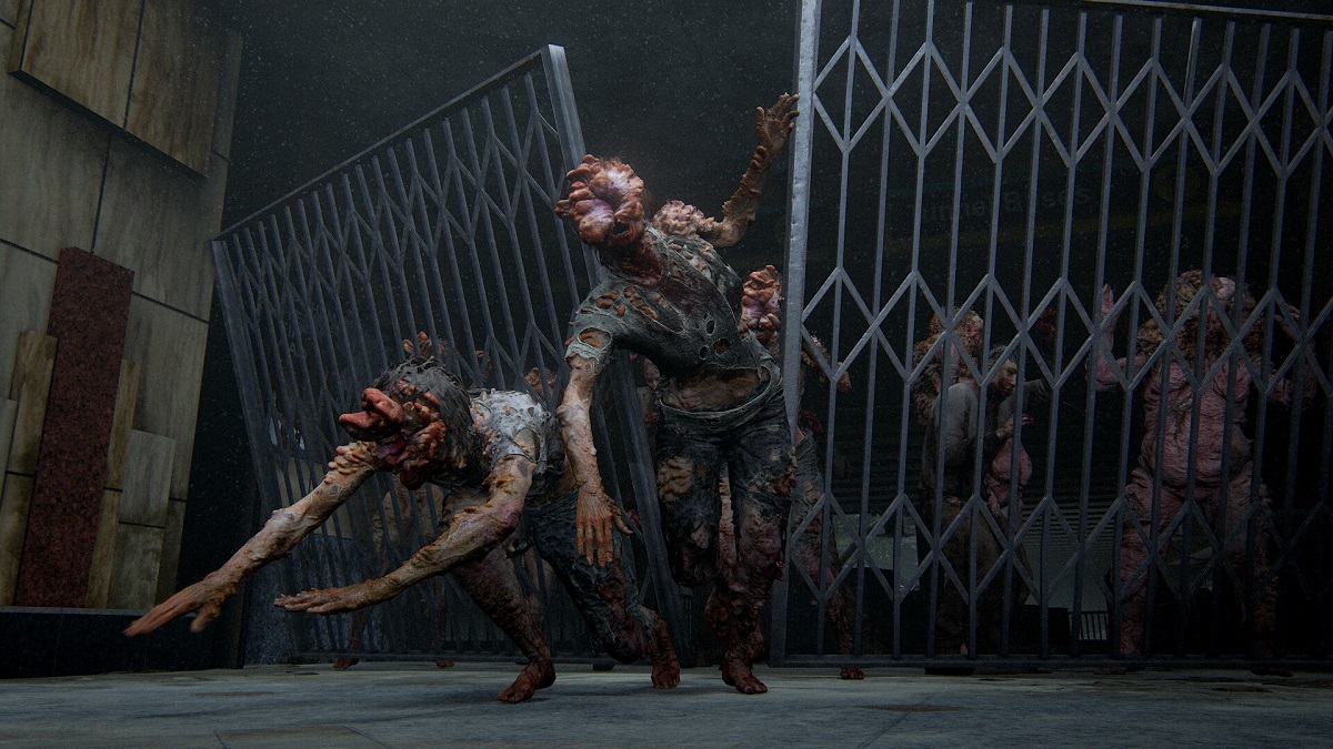 The Last of Us Part 2: a series of Clicker zombies break down a metal gate in pursuit.